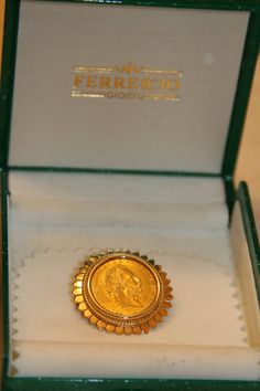 a gold coin sitting inside of a green box