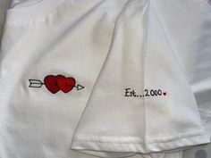 Valentine's couples gift embroidered T-Shirt organic cotton, mens and ladies sizes Help custom make a romantic T-shirt for yourself or a loved one or why not have matching Tees :)  Firstly choose the heart design you would like, please have a look at the images for options, next decide if you require any text for the sleeve. You may wish to have names, a date or a meaningful word/words. You can message me these details after the sale and I will create a free motion embroidered t-shirt just for you.  Free-motion embroidery means I can draw or trace any image using my sewing machine like a pen.  This gives me a lot of flexibility and I can tailor designs to suit your needs and requirements.  I currently only stock organic white cotton T-shirts but I can source additional colours such as navy White Family Matching T-shirt With Embroidered Text, Family Matching White T-shirt With Embroidered Text, White Embroidered T-shirt For Family Matching, White T-shirt With Embroidered Logo As Gift, Couples Cotton T-shirt Gift, Couples Cotton T-shirt For Gift, White T-shirt With Embroidered Graphics As Gift, Customizable Cotton Tops For Anniversary, White Embroidered T-shirt For Gift