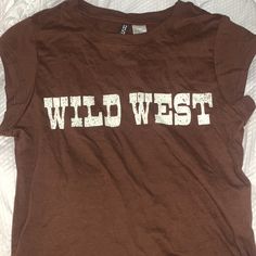 Xs Brown Wild West T-Shirt. Never Worn With Tags! Trendy H&m Graphic Print T-shirt, Brown Letter Print Top For Summer, Brown Short Sleeve Tops With Letter Print, H&m Crew Neck T-shirt With Letter Print, Casual Muscle Tee With Letter Print, Brown Graphic Tee With Logo Print, Casual Brown T-shirt With Text Print, Brown Crew Neck Top With Letter Print, H&m Letter Print T-shirt For Summer