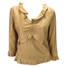 Presenting a saddle-colored leather ruffled Gucci top, designed by Tom Ford. From the Spring/Summer 1999 collection, fabric versions of this top debuted on the season's runway. This incredible top is constructed entirely of soft lightweight leather in saddle color. The shirt features cropped sleeves, a v-neckline, and ruching at the bust. Made complete with ruffle details at the neckline, waist, hem, and cuffs this late 1990s top is the perfect addition to any Tom Ford Gucci lover's wardrobe. Ap Designer Silk Tops With Ruffles, Luxury Spring Ruffled Top, Luxury Ruffled Tops For Spring, Luxury Spring Tops With Ruffles, Designer Fitted Tops With Ruffles, Luxury Fitted Ruffle Tops, Gucci By Tom Ford, Tom Ford Gucci, Gucci Top