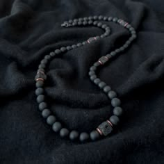 A grounding stone, Onyx is believed to absorb negative energies, alleviates worries and tensions, and eliminates confusion. It helps in being structured and letting go of unhappy thoughts. There is 1 accent cube Lava Stone bead, which is repeated multiple times for Balance. A grounding stone, Lava Stone is believed to provide stability during times of change and encourages strength and courage. It promotes change where needed for behavioral issues and enhances fertility. This necklace has an ela Men Necklace With Stone, Men’s Necklace Layering, Men Crystal Necklace, Mens Stone Necklace, Black Necklace Men, Men’s Beaded Necklace, Necklace For Men Aesthetic, Lava Necklace, Men Boho