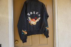 Vintage embroidered KOREA souvenir jacket. Labeled size XL. Good vintage condition. Measurements taken across front lying flat23" armpit to armpit15" across waist26" length Streetwear Long Sleeve Tops With Embroidered Patch, Fall Outerwear With Floral Embroidery, Embroidered Cuffs Long Sleeve Outerwear For Streetwear, Long Sleeve Outerwear With Embroidered Cuffs For Streetwear, Embroidered Patch Tops For Streetwear In Fall, Spring Embroidered Crew Neck Outerwear, Casual Cotton Outerwear With Embroidered Cuffs, Spring Streetwear Tops With Custom Embroidery, Souvenir Jacket