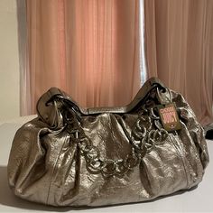 Juicy Couture Silver Bag. I Believe This To Be Very Rare And Vintage! It Has Been Sitting Away In Storage All Of Its Life. This Baby Comes With All The Original Packaging/Stuffing And New Tags! Only Flaw Is On The Zipper And Is Pictured. Sold As Is. Price Is Subject To Change, Please Send In Offers! Will Provide Measurements If Needed..Its Large. Designer Silver Bag With Gold-tone Hardware, Designer Silver Bags With Gold-tone Hardware, Chic Gold Shoulder Bag With Silver-tone Hardware, Elegant Gold Hobo Bag With Top Handle, Trendy Metallic Shoulder Bag For Formal Occasions, Luxury Hobo Shoulder Bag For Party, Luxury Metallic Clutch Shoulder Bag, Luxury Metallic Clutch Bag, Designer Gold Hobo Bag For Evenings