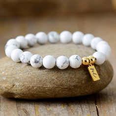 The Handmade Natural Howlite Beaded Bracelet with a Gold Plated Tag looks great. It will make the perfect gift 🎁 for someone special, or treat yourself as you deserve it 💖 🥰 These Bracelets have been made using high quality Natural Howlite and have a Gold Plated Tag with MC for MantraChakra. They are available as 4mm, 6mm and 8mm. Howlite Strengthens Memory and stimulates desire for knowledge. Howlite is a calming stone, a stone of patience and perspective and can help when you have a lot of White Charm Bracelet With 8mm Beads As Gift, Minimalist Letter Beads Stretch Bracelet As Gift, Classic Round Beads Bracelet For Gift, Minimalist Letter Beads Stretch Bracelet Gift, White Name Bracelet With 8mm Beads As Gift, Classic Stretch Bracelet With Round Beads As Gift, Classic White Beaded Bracelets As Gift, Classic White Beaded Bracelets For Gift, Classic Stretch Bracelet As Gift