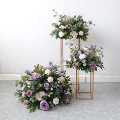 two gold plant stands with flowers on them