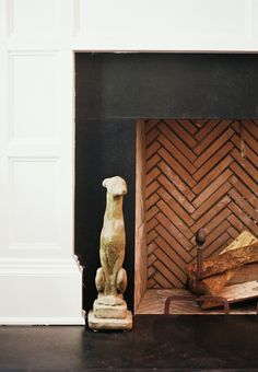 a fireplace with a dog statue next to it