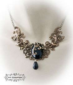 "♥♥Noir Romantique♥♥ Welcome to my store! \"Eternal beauty \"necklace A necklace comprised of 2 bronze rococo flourishes (42x22mm each) perfect detailed set on the left and right of bronze crown setting that is placed upon a central ornament in the middle and finally holds a get black gem 25x18mm. Flourish detail is attached to the gem. Black teardop bead is hanging. ------- If you need a specific lenght contact me :) ------------ ♥♥ The metal parts are of high quality brass ♥♥ Nickel and lead f Gothic Gold Pendant Necklace, Gothic Gold Necklace For Wedding, Gold Gothic Necklace For Wedding, Gothic Metal Necklace With Antique Finish, Gothic Bronze Jewelry With Antique Finish, Gothic Pendant Necklace With Antique Finish, Victorian Bronze Necklaces With Intricate Design, Gothic Gold Filigree Jewelry, Gothic Black Brass Jewelry