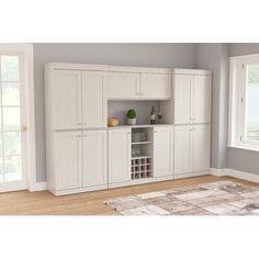 an empty living room with white cabinets and wood floors