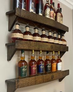 a shelf filled with bottles of liquor on top of a wall