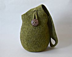 a small green bag with a button on it