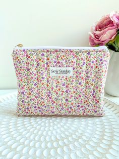 Our large quilted makeup pouch is handmade using cotton fabric. It offers function and style and fits perfectly in your handbag while you're on the go. We recommend using it for cosmetics, skincare, haircare, stationary and other accessories.  Featuring a floral design, stunning gold zipper pull and a beige lining. Perfect for travel and everyday use. Dimensions of product  21cm width x 16cm height Care instructions Hand wash recommended or machine cold wash on gentle cycle in wash bag Everyday Quilted Pouch Cosmetic Bag, Everyday Quilted Rectangular Pouch, Rectangular Quilted Pouch, Quilted Cosmetic Pouch Bag As Gift, Quilted Pouch Cosmetic Bag, Quilted Pouch Cosmetic Bag Gift, Quilted Pouch Cosmetic Bag As Gift, Quilted Pouch Bag For Gift, Quilted Pouch Bag As Gift