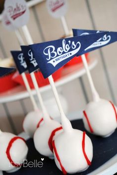 cake pops with red, white and blue flags are on a plate in front of other desserts