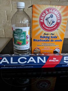 a bottle of baking soda sitting on top of a table next to a box of baking soda