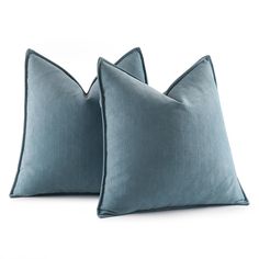 two blue pillows sitting next to each other