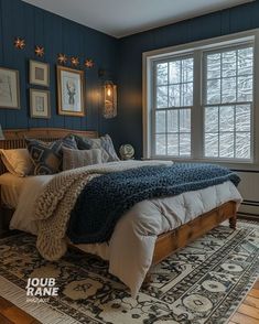 a bedroom with blue walls and wood floors has a large bed in the middle, along with two framed pictures on the wall