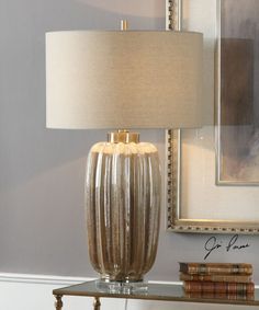 a lamp that is on top of a table next to a book shelf with books