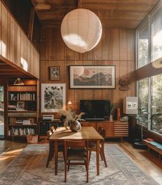 a living room filled with furniture and a wooden table in front of a large window