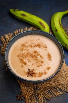 an image of a bowl of pudding with cinnamon on top and bananas in the background