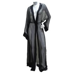 Introducing the 1980s Sheer Silk Hooded Robe – a mesmerizing and versatile wardrobe essential that effortlessly blends luxury with a touch of bohemian flair. This floor-length sheer black silk robe is not just a garment; it's a unique styling piece that allows you to express your individuality. Embrace the allure of sheer black silk that drapes gracefully, creating an ethereal and enchanting look. The sheer fabric adds a layer of sophistication and mystique to your ensemble. Define and flatter y Black Sheer Robe, Black Silk Robe, Yves Saint Laurent Dress, Sheer Robe, Unique Styling, Hooded Robe, Versatile Wardrobe, Silk Robe, Sheer Fabric