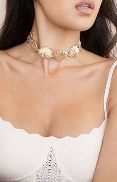 Online only! Turn heads with Ettika's Scallop Shell Body Chain, featuring a striking seashell design that drapes elegantly across the body. The gold finish adds a touch of luxury, making it a standout accessory for any occasion.


	Gold Tone, Zinc
	31" with 7" extender
	Lobster Clasp Chic Silver Beach Jewelry, Chic Silver Jewelry For Beach, Chic Silver Jewelry For The Beach, Shell-shaped Clavicle Chain Necklace, Elegant Shell Jewelry For Parties, Gold Metal Choker, Gold Summer Choker, Elegant Summer Beach Choker, Elegant Shell Necklaces For Summer