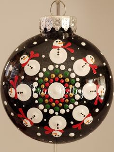 a glass ornament with snowmen on it