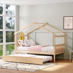 a bed with a wooden frame and mattress in front of a large window that overlooks a grassy field