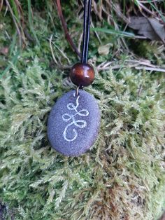 Hand carved Unalome symbol on stone necklace with silver enamel inlay. Leather cord is 1m long, 1.5mm thick and tied into a sliding knot necklace. Pendant is attached to the cord by a copper plated hoop. Includes a black velvet pouch. Pieces are unique and may slightly differ in colour and size, as is the nature with hand carved natural stones :) Thanks! Holistic Jewelry With Adjustable Cord For Meditation, Spiritual Necklace With Adjustable Cord, Adjustable Carved Spiritual Necklace, Adjustable Symbolic Engraved Necklace, Symbolic Engraved Adjustable Necklace, Adjustable Engraved Spiritual Necklaces, Engraved Adjustable Spiritual Necklaces, Spiritual Adjustable Necklace With Oval Pendant, Engraved Adjustable Spiritual Necklace