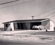 an old black and white photo of a house with a car parked in the driveway