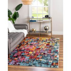 a living room with a gray couch and colorful rug