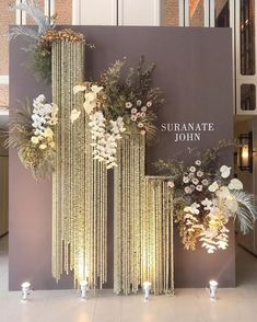 a display with flowers and candles in front of a sign that says sufranate john