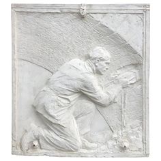 a white sculpture with a man kneeling down next to a dog