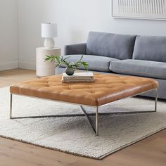 a living room with a couch, coffee table and rugs on the floor in front of it