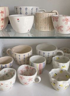 a shelf filled with lots of different types of cups