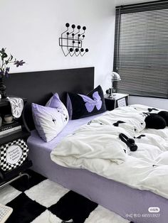 a black and white bedroom with lots of pillows