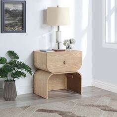 a wooden table with a lamp on it next to a potted plant