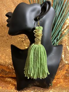 a black mannequin head with green tassels