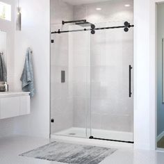 a white bathroom with a walk in shower next to a sink