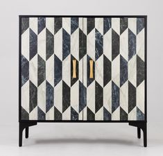 an art deco cabinet with black and white marble inlays, gold handles and brass accents