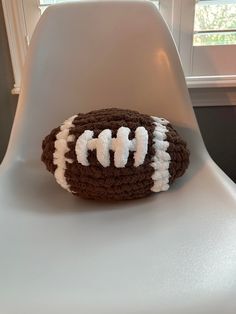 a crocheted football sitting on top of a white chair