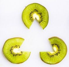 four slices of kiwi fruit arranged in the shape of a circle on a white surface