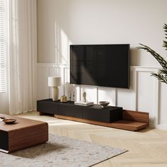 a flat screen tv sitting on top of a wooden stand in front of a window