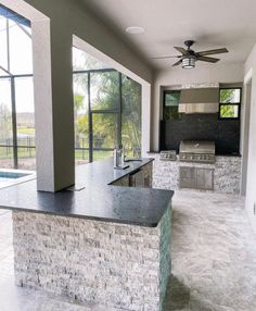 an outdoor kitchen and living room with large windows