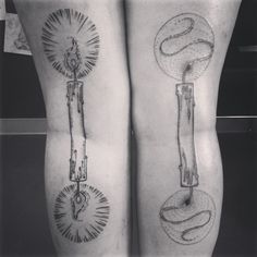 black and white photo of two legs with tattoos on them, one is holding a candle