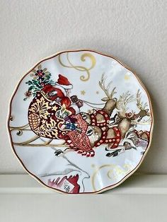 a white plate with reindeers on it sitting on a shelf next to a wall