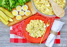 an assortment of food is displayed on a red and white checkered tablecloth with utensils