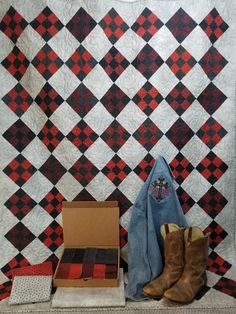 two pairs of boots are sitting next to a quilt