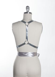 Romantic & light, the Twilight Harness is a softer take on the leather harness. The leather contrasts beautifully with the metal hardware and the soft satin ribbons which wrap around the waist to tie into a bow. Extra-soft and silky double-faced satin ribbon imported from Japan gives this piece a luxurious look and feel.Fit is adjustable with buckles and straps. Silver toned nickel plated steel hardware. Shown in silver metallic leather (silver leather is now lined and stitched). Also available Fashion Harness, Harness Belt, Romantic Lighting, Bow Belt, Leather Art, Leather Harness, Choker Collar, Ribbon Tie, Leather Silver