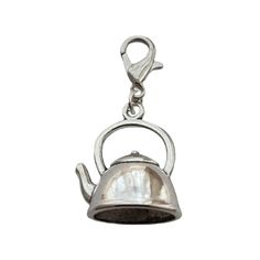 a silver teapot charm on a white background