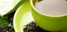 a green tea cup and saucer filled with black tea