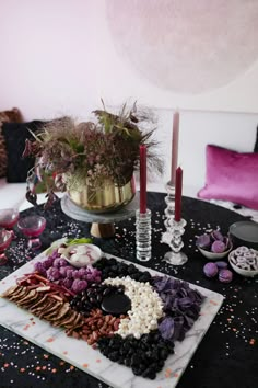 a table topped with lots of different types of food and candles on top of it